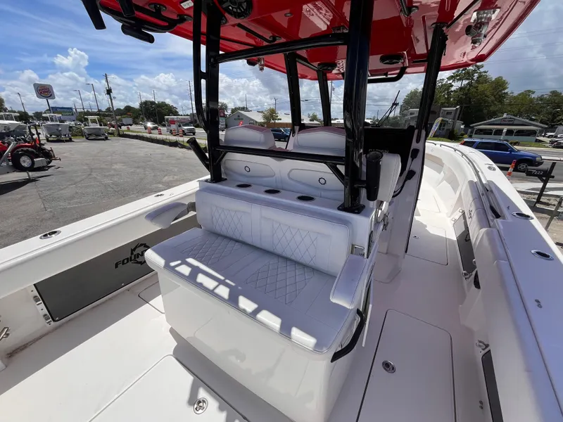 Slide: The Image of 2023 Fountain 38 Tournament Edition boat interior with seating and console, parked outdoors. - 9