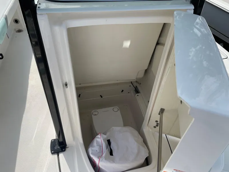 Slide: The Image of 2024 Robalo 226 Cayman boat storage compartment with open hatch, showcasing interior space. - 10