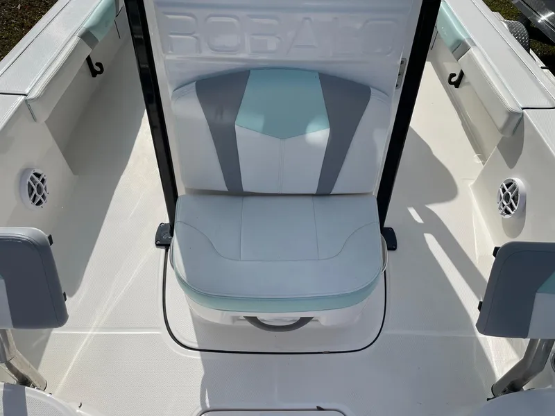 Slide: The Image of 2024 Robalo 226 Cayman boat interior with cushioned seating and speaker system. - 11