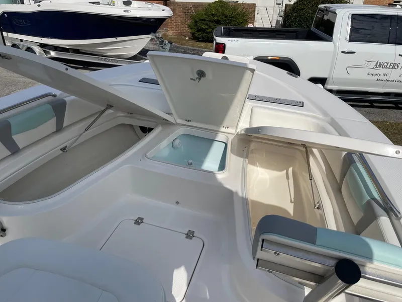 Slide: The Image of 2024 Robalo 226 Cayman boat interior with open storage compartments and seating. - 12