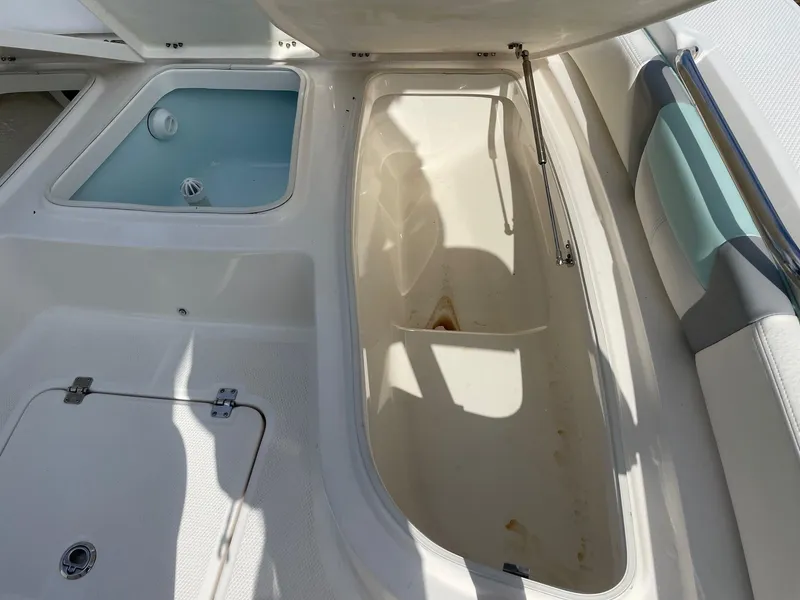 Slide: The Image of 2024 Robalo 226 Cayman boat storage compartments and seating area. - 13