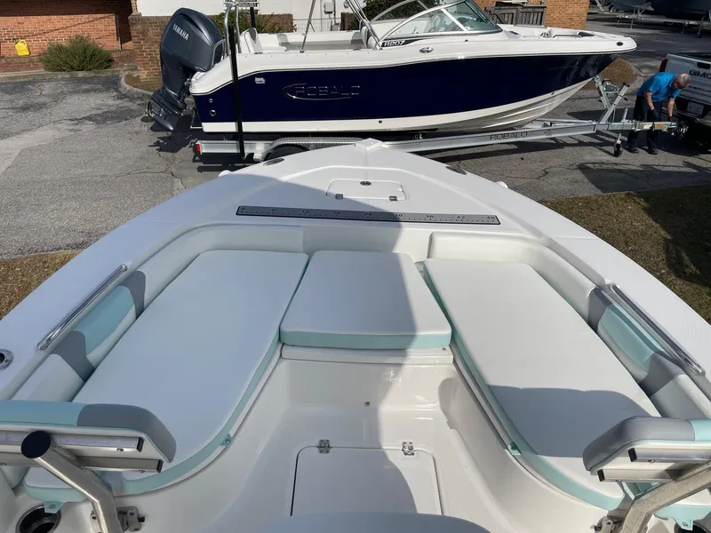Slide: The Image of 2024 Robalo 226 Cayman boat interior with cushioned seating, parked on a trailer. - 6