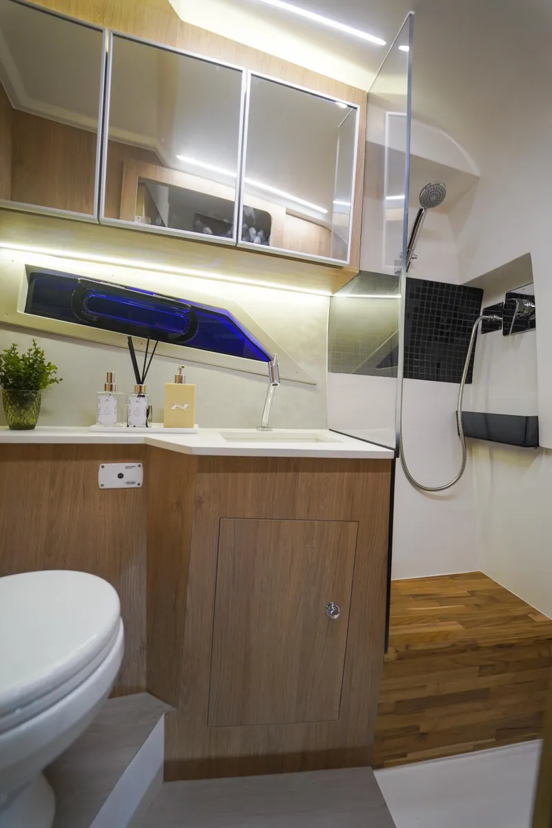 Slide: The Image of 2024 NX Boats NX360 Sports Coupe bathroom with modern fixtures and wooden accents. - 13