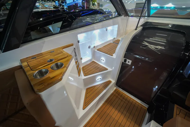 Slide: The Image of Interior of 2024 NX Boats NX360 Sports Coupe with wooden steps and cup holders. - 6
