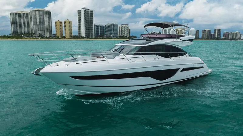 Slide: The Image of Luxurious 2022 Princess S66 yacht cruising near city skyline on turquoise waters. - 28