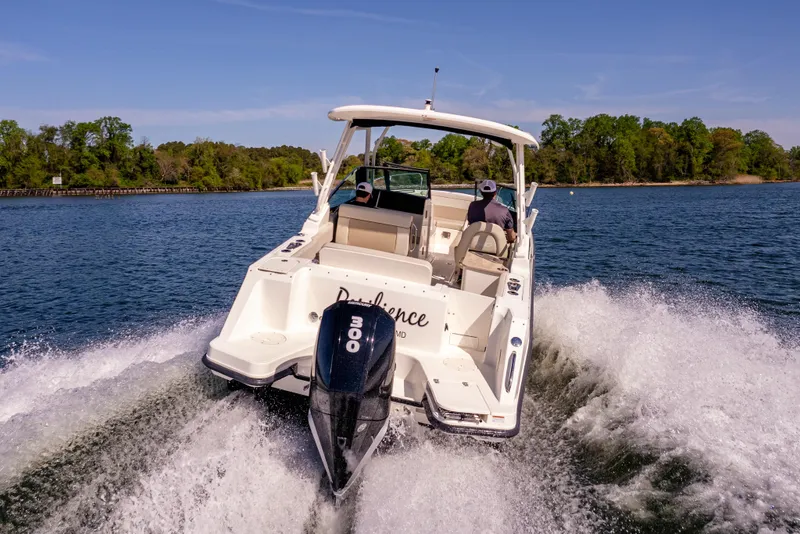 Slide: The Image of 2022 Boston Whaler 240 Vantage cruising on a scenic lake. - 11