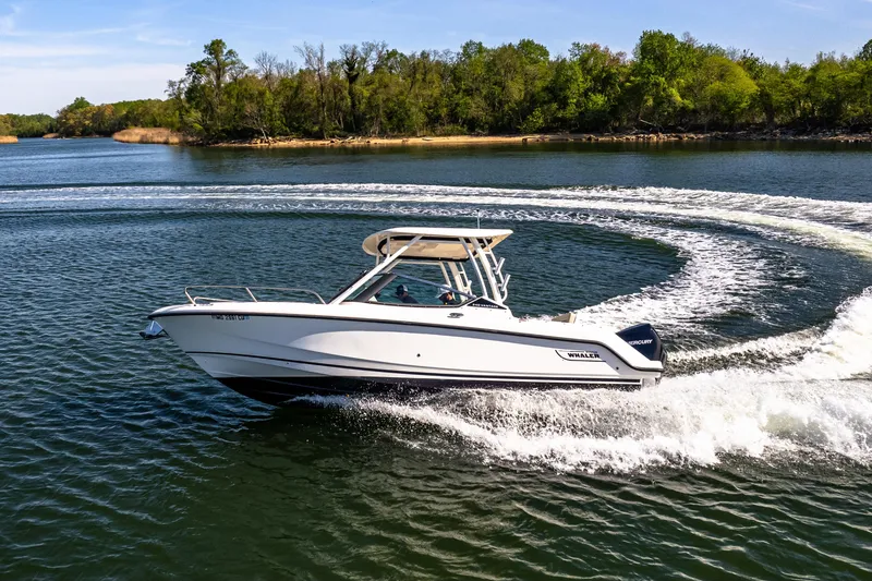 Slide: The Image of 2022 Boston Whaler 240 Vantage cruising on a scenic lake. - 13
