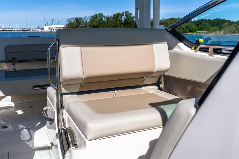 Slide: The Image of 2022 Boston Whaler 240 Vantage boat interior with beige seating and scenic water view. - 14