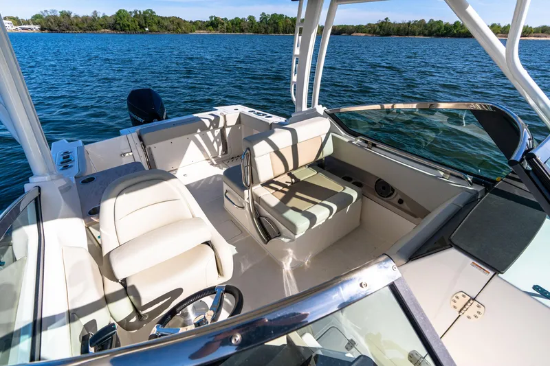 Slide: The Image of 2022 Boston Whaler 240 Vantage boat interior with seating, steering wheel, and water view. - 19