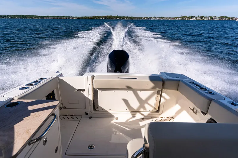 Slide: The Image of 2022 Boston Whaler 240 Vantage cruising on open water, leaving a wake behind. - 2