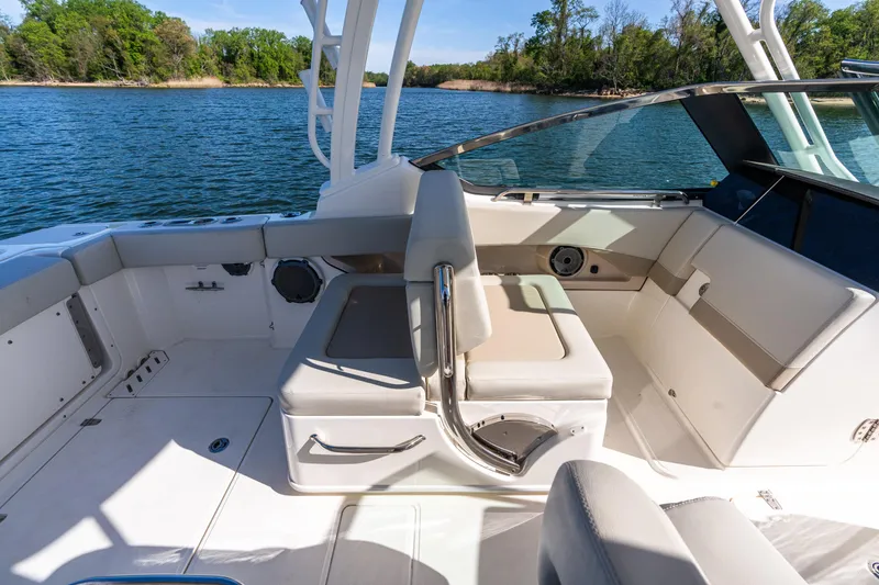 Slide: The Image of 2022 Boston Whaler 240 Vantage boat interior with seating, on a serene lake. - 21