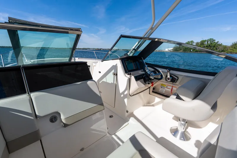 Slide: The Image of 2022 Boston Whaler 240 Vantage boat interior with helm and seating, on a sunny day. - 22