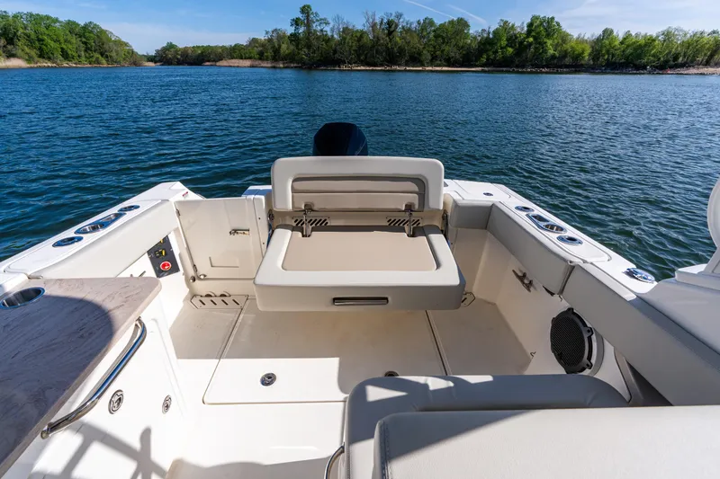 Slide: The Image of 2022 Boston Whaler 240 Vantage boat interior with seating, on a calm lake. - 24