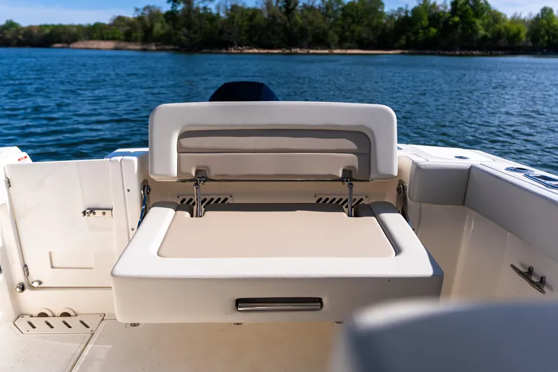 Slide: The Image of 2022 Boston Whaler 240 Vantage boat with foldable seating, on a serene lake backdrop. - 25