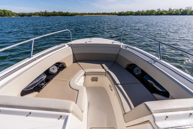 Slide: The Image of 2022 Boston Whaler 240 Vantage boat interior with cushioned seating on a calm lake. - 3