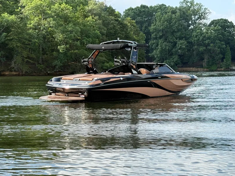 Slide: The Image of 2022 Centurion Fi23 boat on a calm lake with lush green trees. - 10