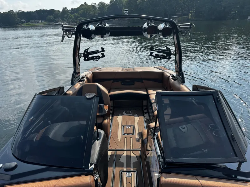 Slide: The Image of 2022 Centurion Fi23 boat interior with brown seating, open windshield, and lake view. - 21