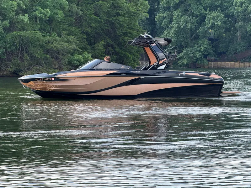 Slide: The Image of 2022 Centurion Fi23 boat on a calm lake with lush green forest background. - 5