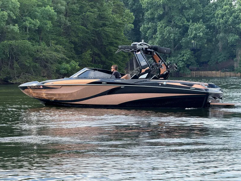 Slide: The Image of 2022 Centurion Fi23 boat on a calm lake, surrounded by lush green trees. - 7