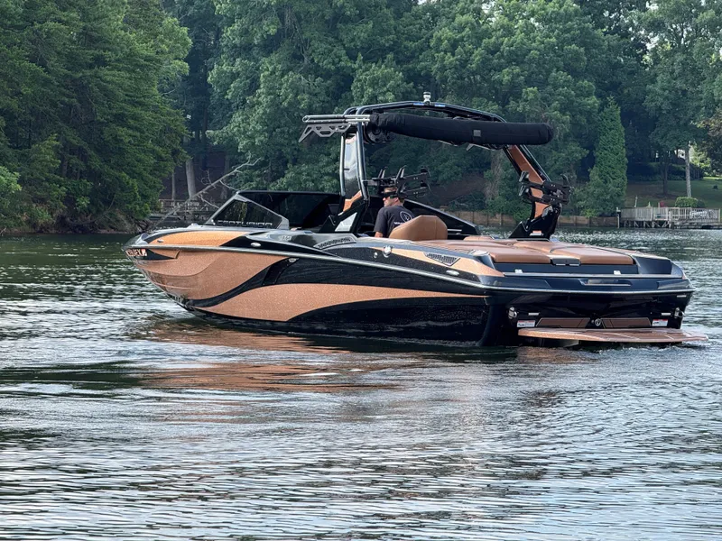 Slide: The Image of 2022 Centurion Fi23 boat on a calm lake, surrounded by lush green trees. - 8