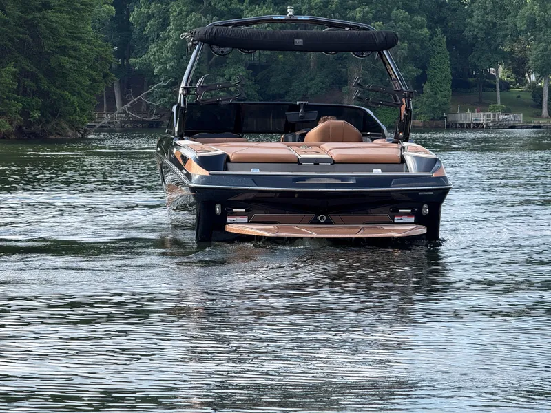 Slide: The Image of 2022 Centurion Fi23 boat cruising on a serene lake surrounded by lush greenery. - 9