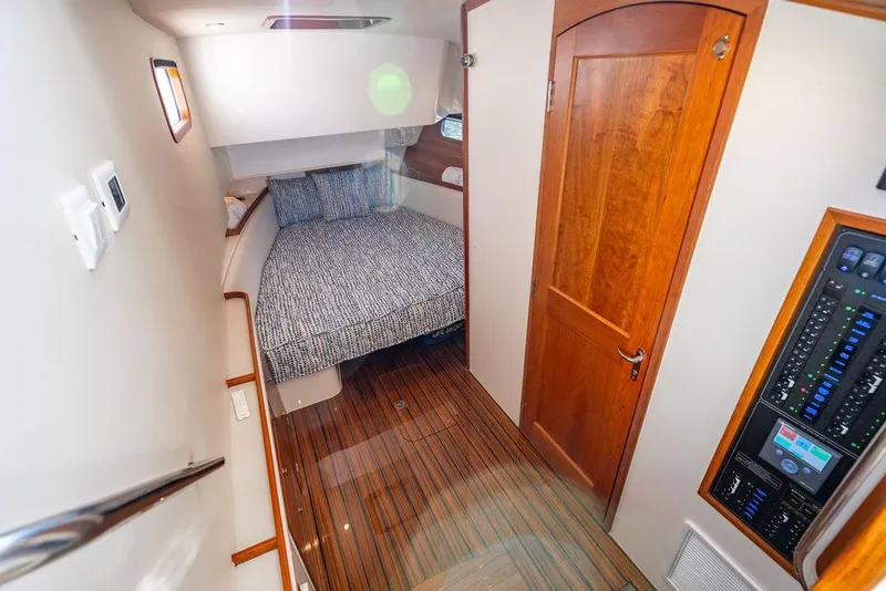 Slide: The Image of 2024 MJM 4 boat interior with cozy cabin, wooden flooring, and control panel. - 25