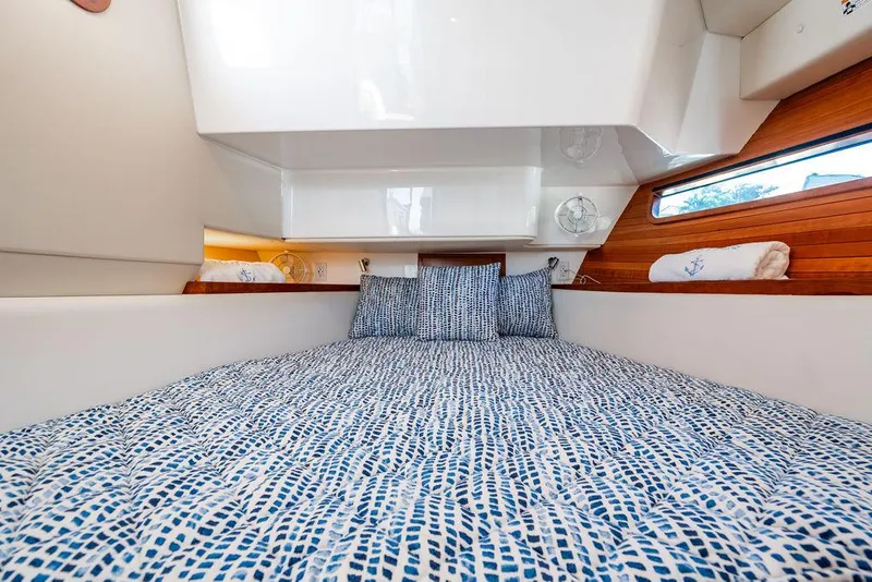 Slide: The Image of 2024 MJM 4 boat interior cabin with patterned bedding and wooden accents. - 28