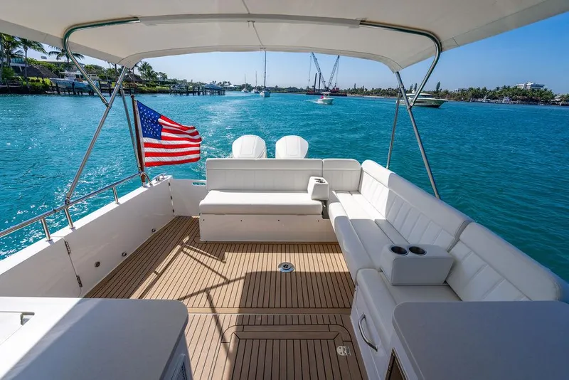 Slide: The Image of 2024 MJM 4 boat with American flag, spacious deck, and scenic water view. - 37
