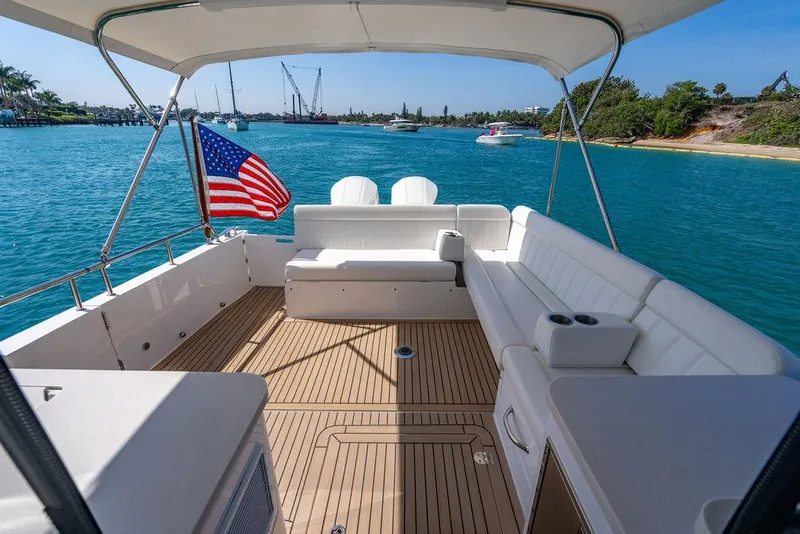 Slide: The Image of 2024 MJM 4 boat with spacious deck, American flag, and scenic water view. - 40