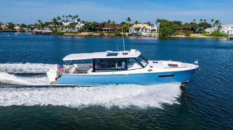 Slide: The Image of 2024 MJM 4 yacht cruising on a sunny day near waterfront homes. - 7