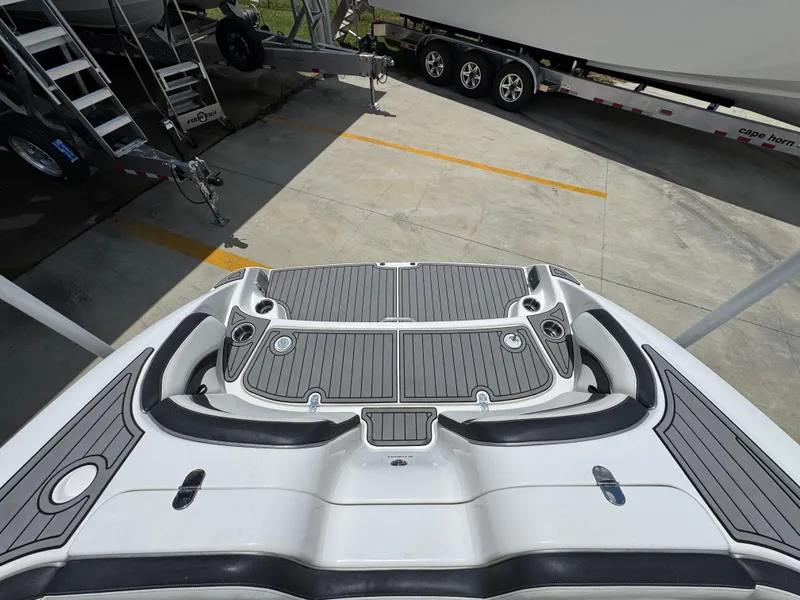 Slide: The Image of 2015 Yamaha Boats AR240 HO swim platform with gray decking, parked on concrete. - 34