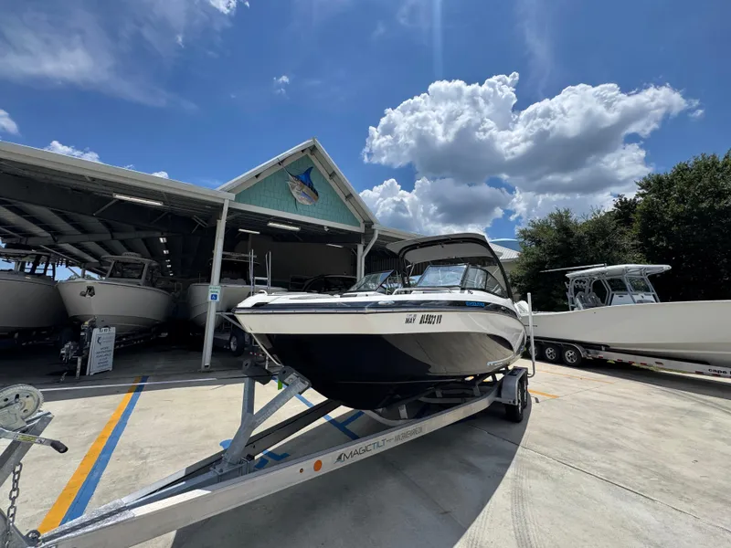 Slide: The Image of 2015 Yamaha Boats AR240 HO on trailer under blue sky at marina. - 4