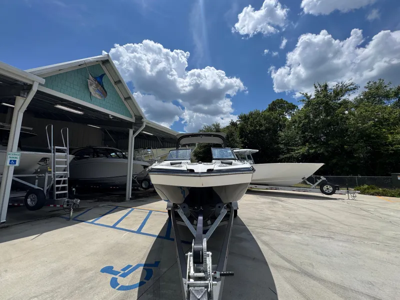 Slide: The Image of 2015 Yamaha Boats AR240 HO on trailer under clear sky at marina. - 6