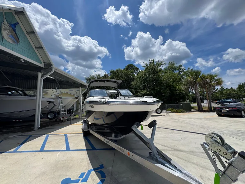 Slide: The Image of 2015 Yamaha Boats AR240 HO on trailer under blue sky at marina. - 7