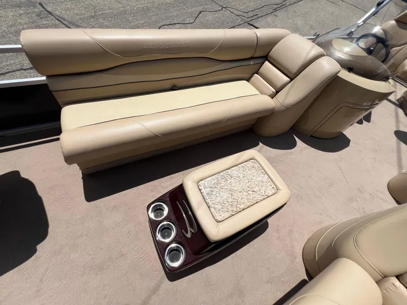 Slide: The Image of 2008 Bennington R25 boat interior with beige seating and cup holders. - 12