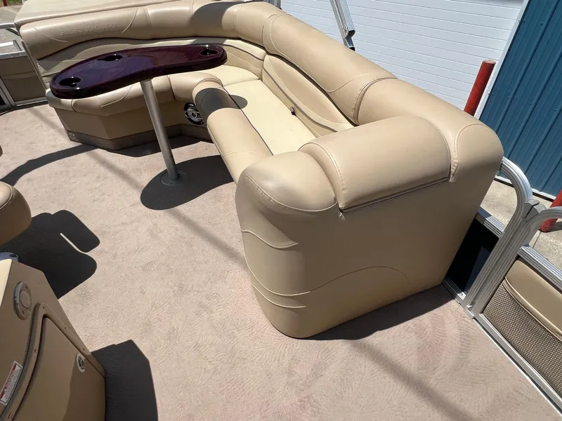 Slide: The Image of 2008 Bennington R25 boat interior with beige seating and a wooden table. - 19