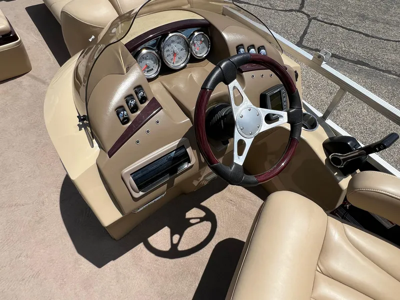 Slide: The Image of 2008 Bennington R25 boat dashboard with steering wheel and gauges, featuring beige interior. - 21
