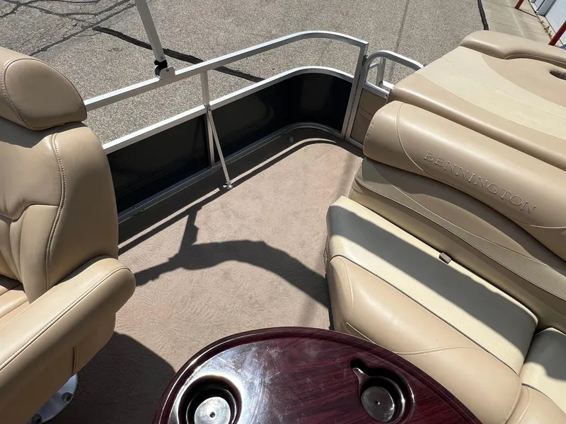 Slide: The Image of 2008 Bennington R25 boat interior with beige seating and a wooden table. - 23