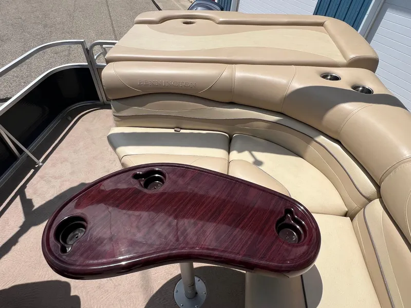 Slide: The Image of Luxurious seating area on a 2008 Bennington R25 pontoon boat with a wooden table. - 25