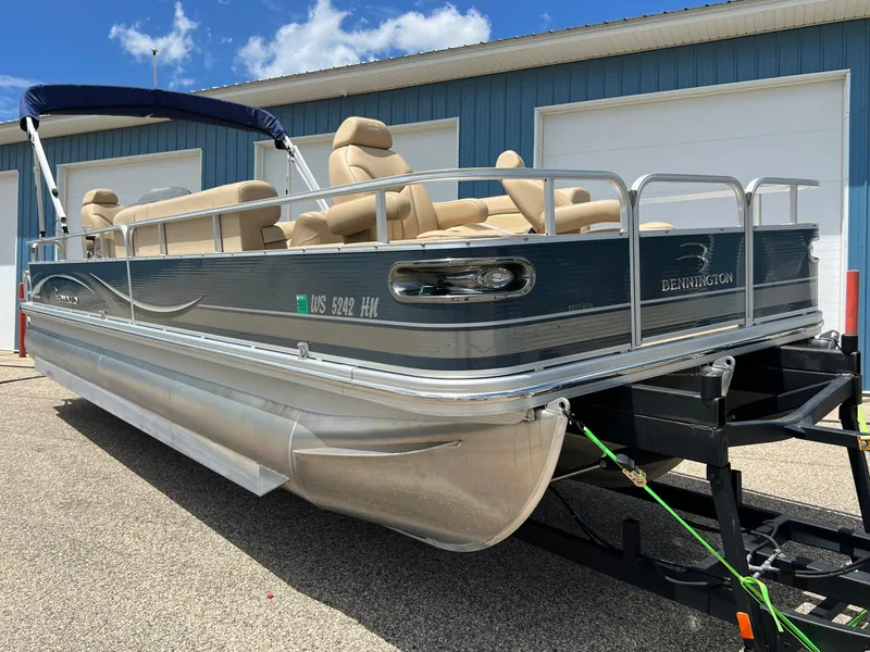 Slide: The Image of 2008 Bennington R25 pontoon boat on trailer, parked outdoors under blue sky. - 3