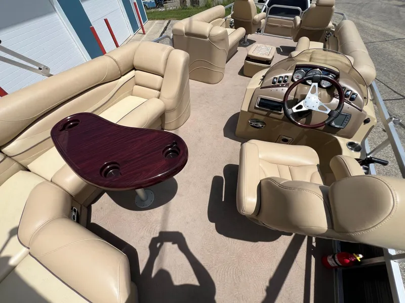 Slide: The Image of 2008 Bennington R25 boat interior with beige seating and a wooden table. - 32