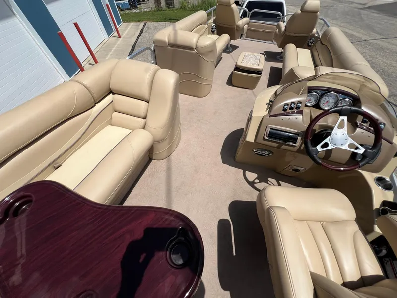Slide: The Image of Luxurious interior of a 2008 Bennington R25 pontoon boat with beige seating and wood accents. - 33