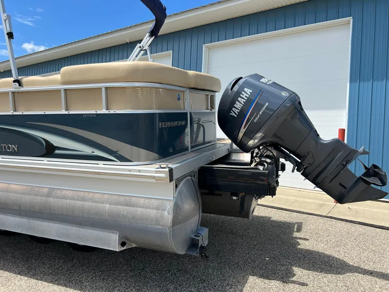 Slide: The Image of 2008 Bennington R25 pontoon boat with Yamaha outboard motor, parked near blue building. - 41