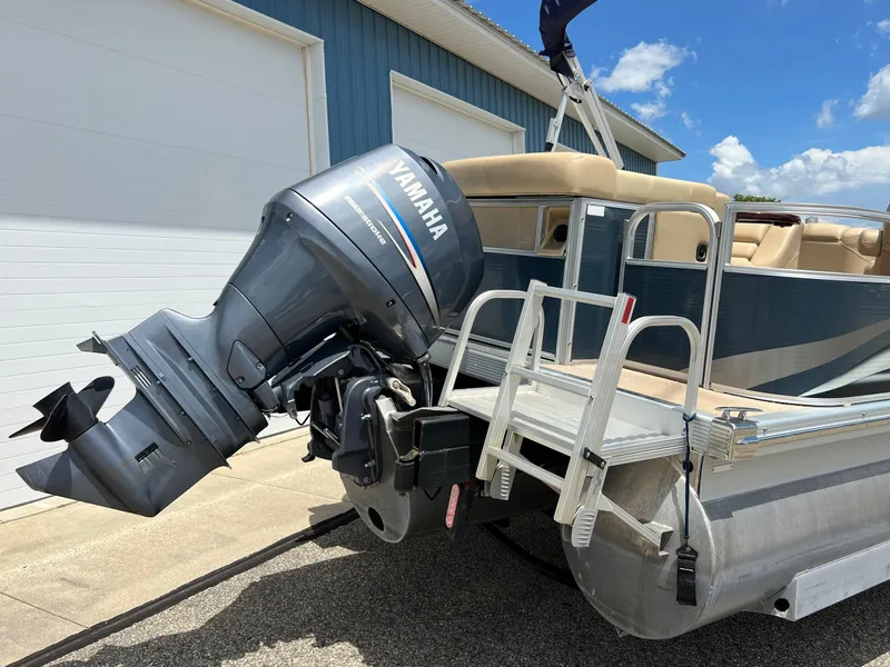 Slide: The Image of 2008 Bennington R25 pontoon boat with Yamaha outboard motor, docked near a blue building. - 6