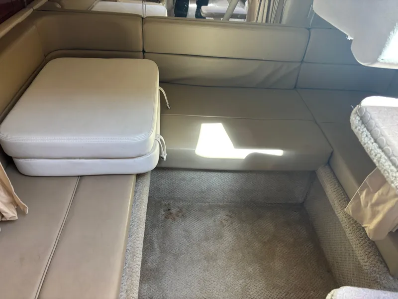 Slide: The Image of Interior seating area of a 2006 Sea Ray 300 Sundancer boat with beige cushions. - 11