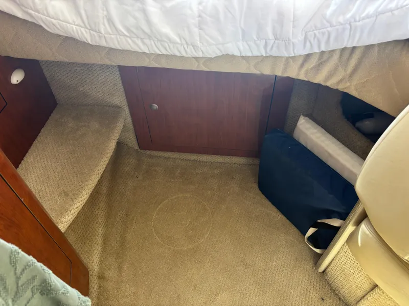 Slide: The Image of Interior cabin of 2006 Sea Ray 300 Sundancer with carpeted floor and wooden cabinet. - 15