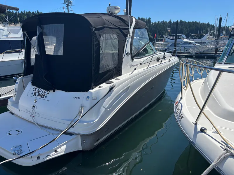 Slide: The Image of 2006 Sea Ray 300 Sundancer docked at marina, featuring black canopy and sleek design. - 2