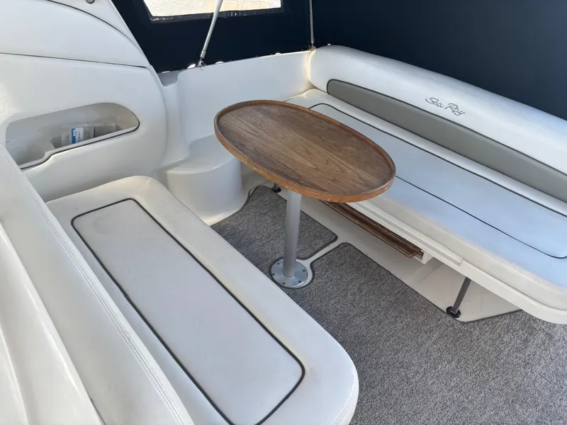 Slide: The Image of Interior of 2006 Sea Ray 300 Sundancer with white seating and wooden table. - 6