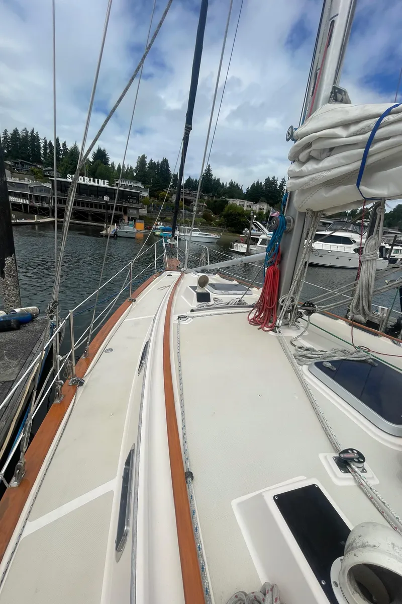 Slide: The Image of 1995 Island Packet 40 sailboat docked at marina, with clear sky and waterfront buildings. - 12