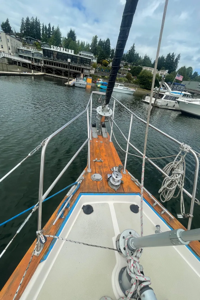 Slide: The Image of Bow view of 1995 Island Packet 40 sailboat docked near shoreline buildings. - 13